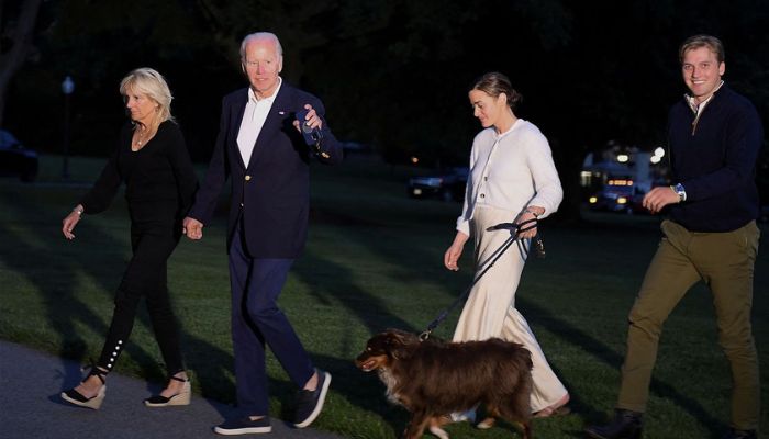 Presiden AS Joe Biden, Ibu Negara Jill Biden, cucu perempuan mereka Naomi Biden, tunangannya Peter Neal dan anjing Charlie berjalan dari Marine One saat tiba di Gedung Putih, di Washington, AS, 20 Juni 2022.— Reuters