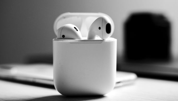 Image shows a black and white picture of Apple AirPods.— Unsplash