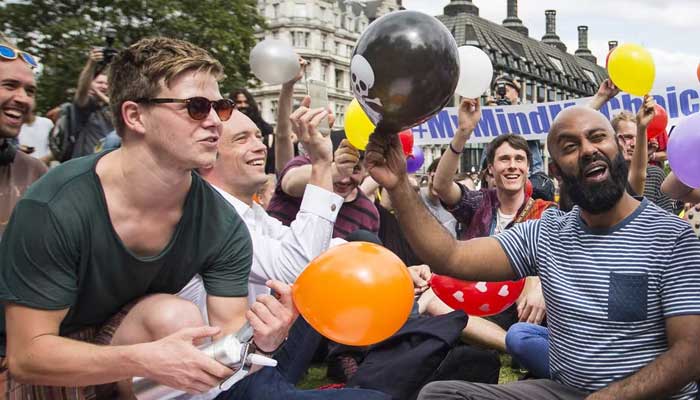 Protesters stage a mass inhalation of Nitrous Oxide, commonly known as laughing gas, outside the Houses of Parliament against the governments proposed Psychoactive Substances Bill on August 1, 2015. — AFP/File