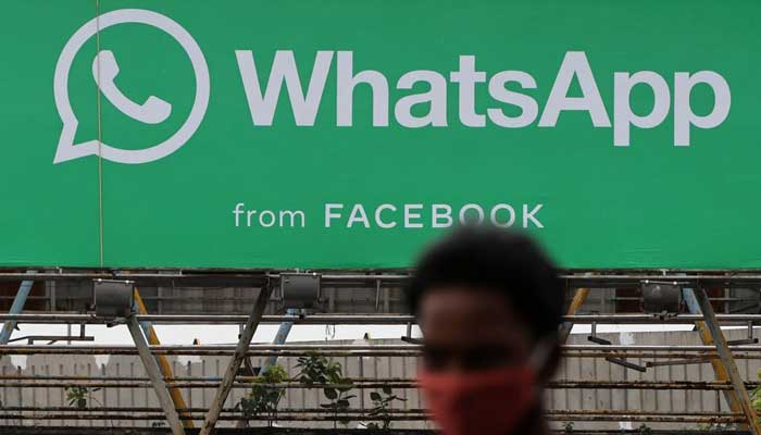 A man walks past a hoarding of the WhatsApp application installed at a skywalk in Mumbai, India, August 26, 2021. — Reuters