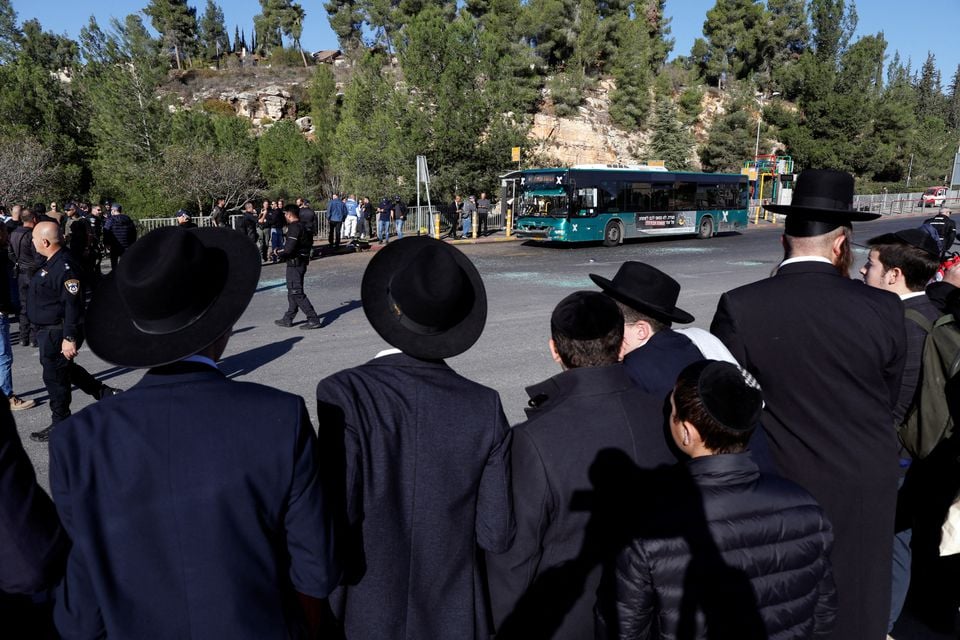 الٹرا آرتھوڈوکس یہودی مرد 23 نومبر 2022 کو یروشلم میں ایک بس اسٹاپ پر دھماکے کے منظر کو دیکھ رہے ہیں۔- رائٹرز