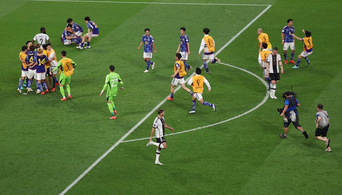 Japan players celebrate after the match as Germany players look dejected. — Reuters