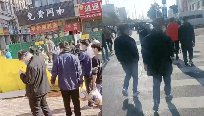 23 نومبر 2022 کو ریلیز ہونے والی ویڈیو سے حاصل کی گئی اس اسکرین گریب میں چین کے شہر ژینگزو میں فاکس کونز پلانٹ پر احتجاج کے بعد لوگوں کا ایک گروپ گرائی ہوئی باڑ کو عبور کر رہا ہے۔— رائٹرز