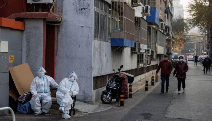 Epidemic prevention workers in protective suits sit in a locked-down residential compound as outbreaks of the coronavirus disease (COVID-19) continue in Beijing, November 23, 2022.— Reuters