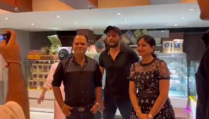 Pakistans former all-rounder poses with fans at a restaurant in Thailand. — Screengrab via Twitter/@SAfridiOfficial