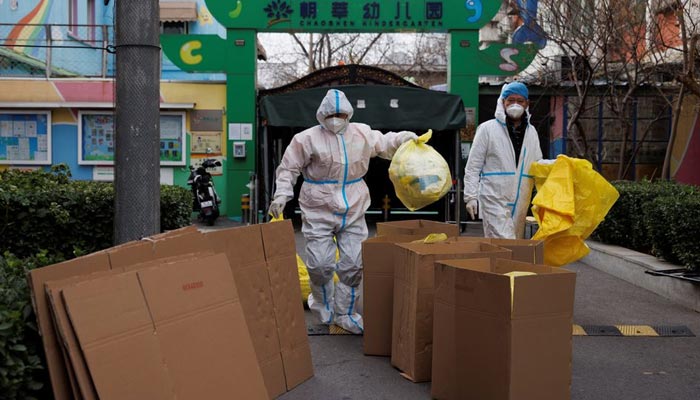 Epidemic prevention workers in protective suits put medical waste into boxes in a residential compound as outbreaks of the coronavirus disease (COVID-19) continue in Beijing, China November 27, 2022. — Reuters