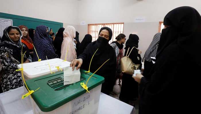 A woman casts her ballot while other wait for their turn at a polling station during the general election in Karachi, Pakistan, July 25, 2018. — Reuters/File