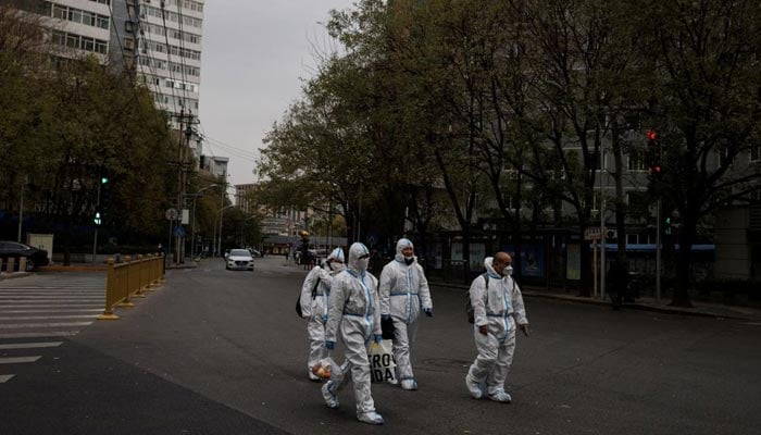 Men in protective suits walk in the street as outbreaks of coronavirus disease (COVID-19) continue in Beijing, China November 28, 2022. — Reuters