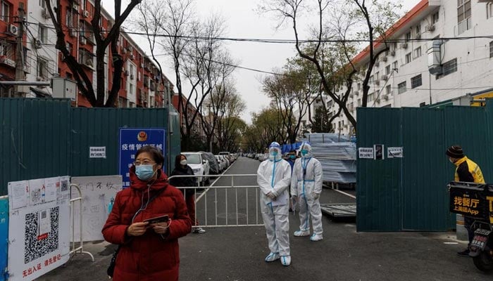 Epidemic-prevention workers in protective suits stand guard at a residential compound as outbreaks of coronavirus disease (COVID-19) continue in Beijing, China November 28, 2022. — Reuters