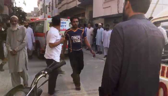 A rescue official (centre) can be seen at a residential area in Malirs Shamsi Society in Karachi, on November 29, 2022. — Afzal Nadeem Dogar