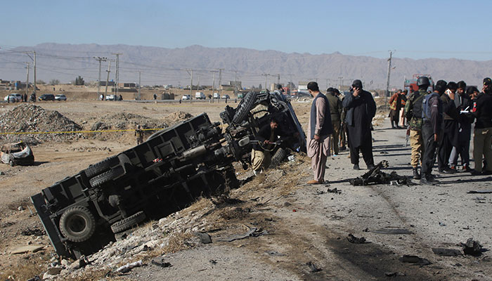 Police officers in civilian clothes survey the aftermath of a suicide bomb blast on a police patrol in Quetta, Pakistan, November 30, 2022. — Reuters