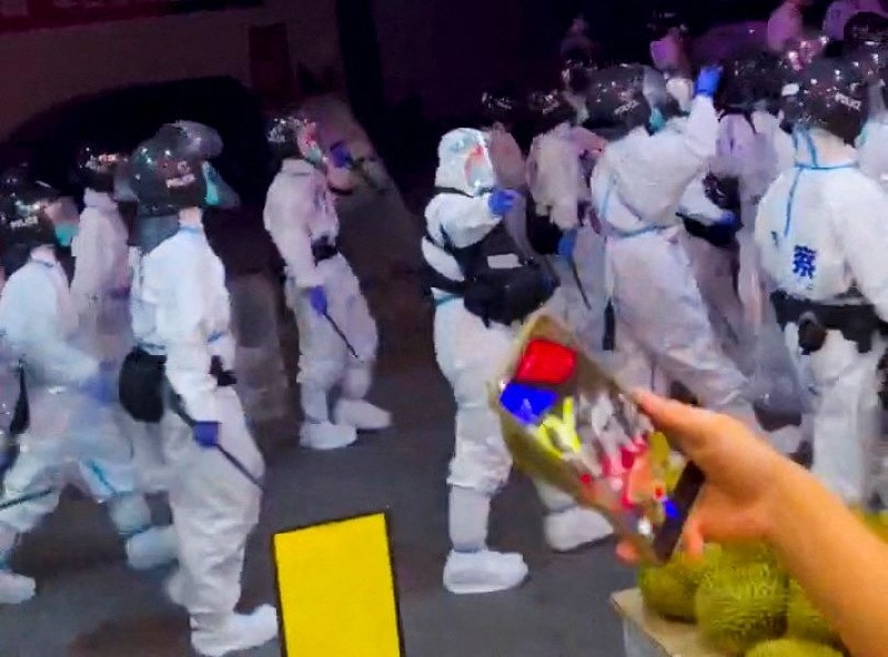 Riot police in personal protection suits (PPE) walk down a street, during protests over coronavirus disease (COVID-19) restrictions, in Guangzhou, Guangdong province, China in this screen grab taken from a social media video released November 29, 2022.— Screengrab via Reuters