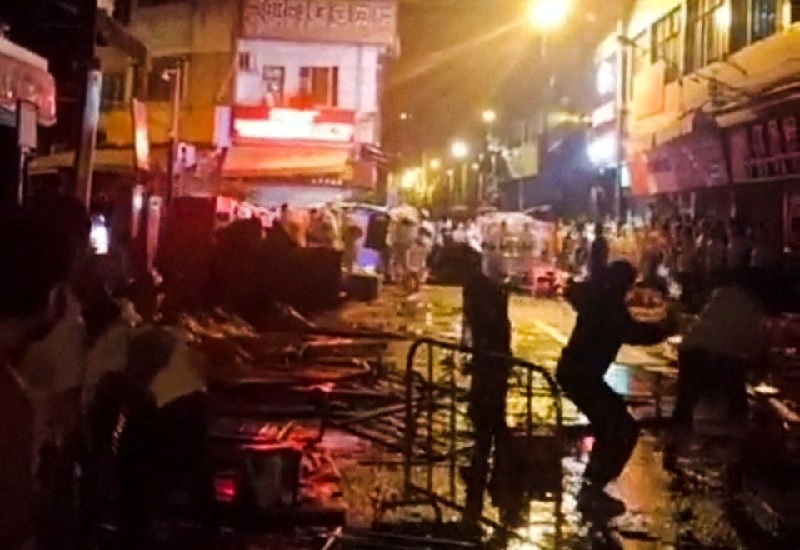 Demonstrators protesting over coronavirus disease (COVID-19) restrictions throw glass bottles towards riot police in Guangzhou, Guangdong province, China in this screen grab taken from a social media video released November 30, 2022.— Screengrab via Reuters