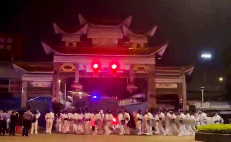 Riot police in personal protection suits (PPE) arrive during protests over coronavirus disease (COVID-19) restrictions, in Guangzhou, Guangdong province, China in this screen grab taken from a social media video released November 29, 2022.  — Screengrab via Reuters