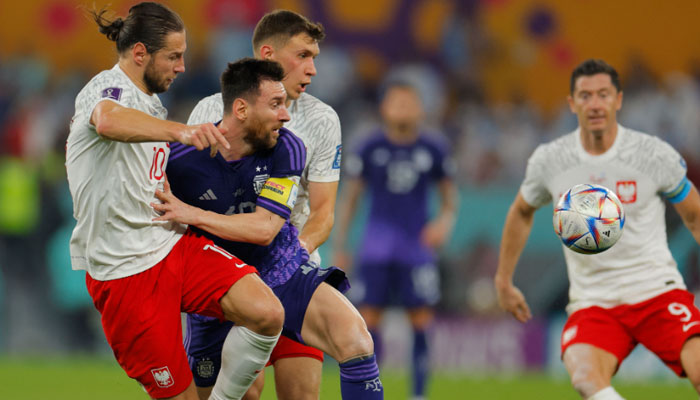 Argentinas forward #10 Lionel Messi (C) fights for the ball with Polands midfielder Grzegorz Krychowiak (L) during the Qatar 2022 World Cup Group C football match between Poland and Argentina at Stadium 974 in Doha on November 30, 2022. AFP