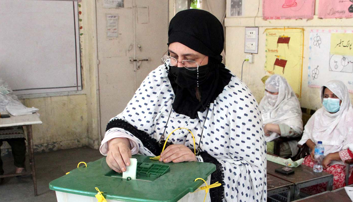 A woman casts her vote at a polling station during the by-election in NA-31 constituency, in Peshawar on October 16, 2022. — PPI