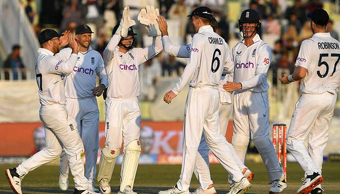 Englands players celebrate after the dismissal of Pakistans captain Babar Azam (not pictured) during the third day of the first cricket Test match between Pakistan and England at the Rawalpindi Cricket Stadium, in Rawalpindi on December 3, 2022. — AFP