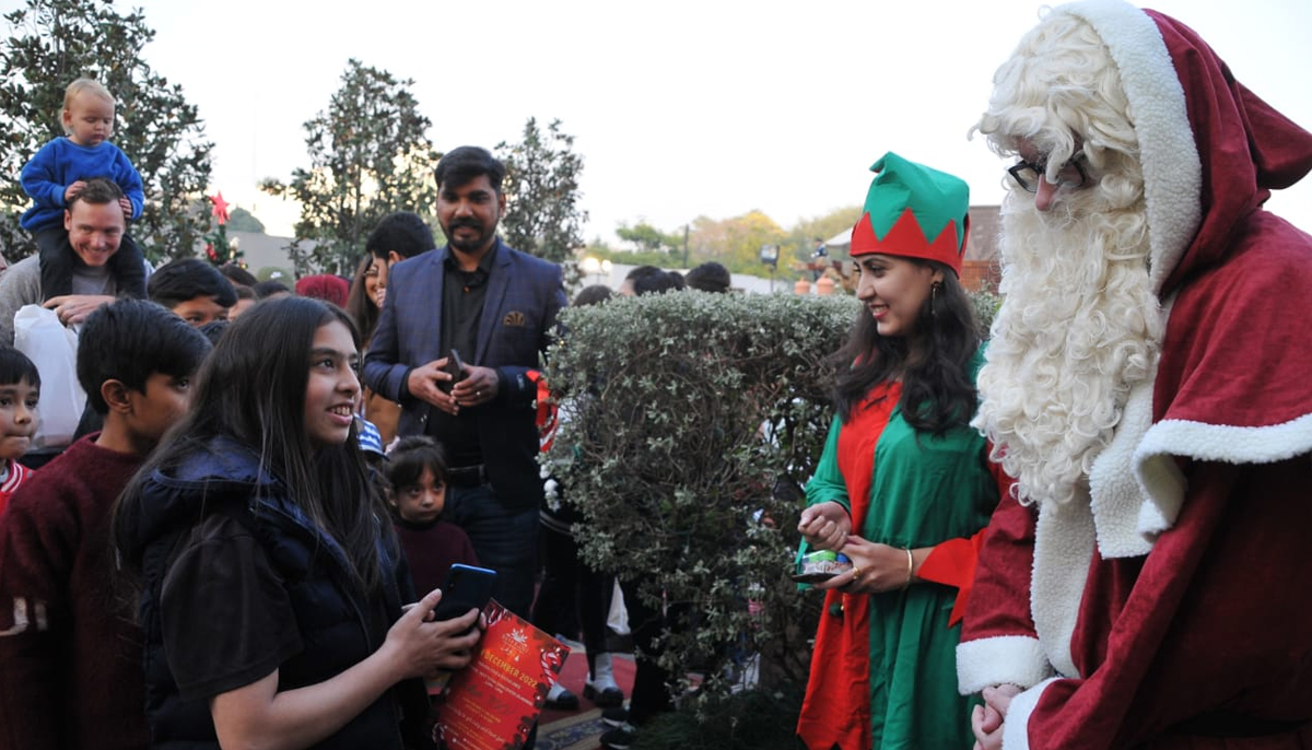 People dressed up in Santa Claus and elf outfits entertain children during the Charity Christmas Market held in Islamabad on December 4, 2022. — Handout from the German Embassy in Islamabad