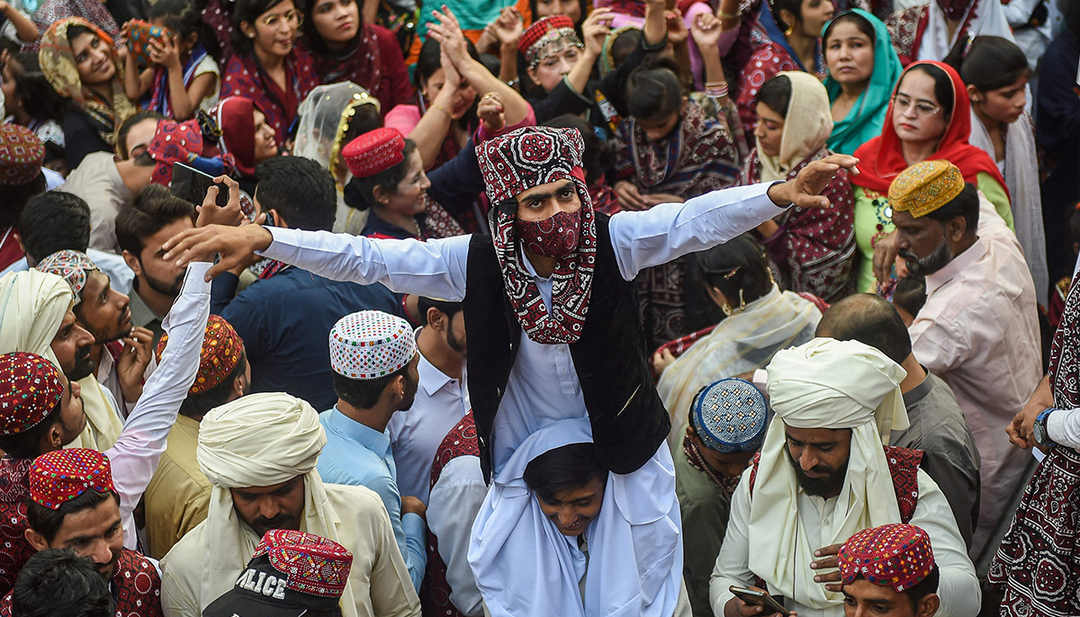 4 دسمبر 2022 کو کراچی میں سندھی ثقافتی دن کے تہوار کے دوران روایتی سندھی لباس پہنے ہوئے لوگ جشن منا رہے ہیں۔ - اے ایف پی