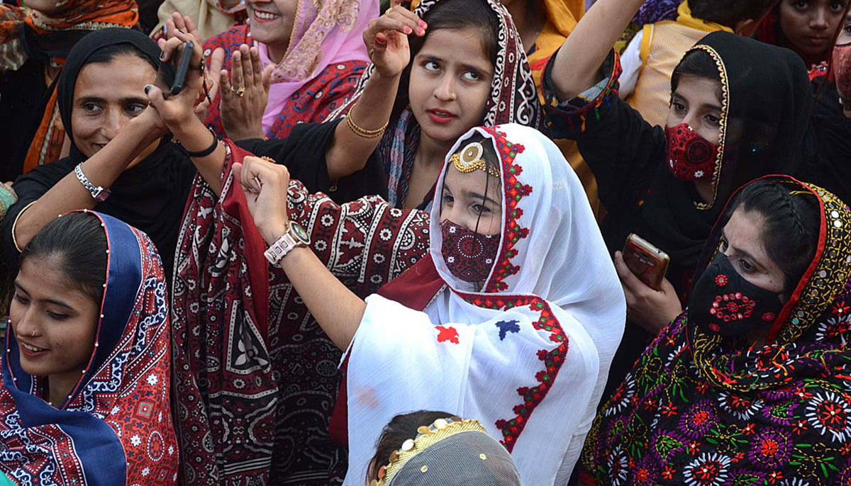 Girls enjoying cultural music during the occasion of Sindhi Cultural Day outside the Karachi Press Club on December 4, 2022. — APP