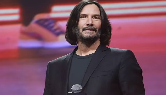 Keanu Reeves looks cheerful at a panel discussion for John Wick: Chapter 4