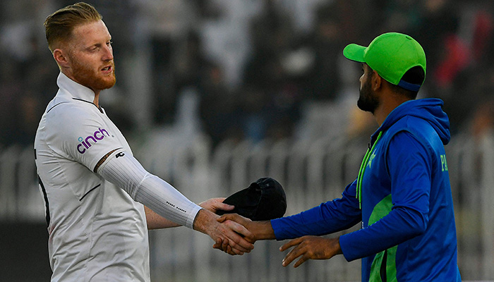 Englands Ben Stokes (L) shakes hands with Pakistans captain Babar Azam after their victory at the end of the fifth and final day of the first cricket Test match between Pakistan and England at the Rawalpindi Cricket Stadium, in Rawalpindi on December 5, 2022. — AFP