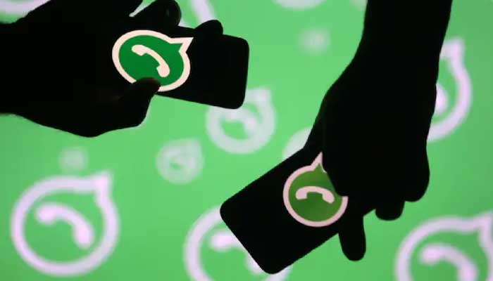 Representational image of WhatsApp logos on smartphones in two hands and in the background. — Reuters/File
