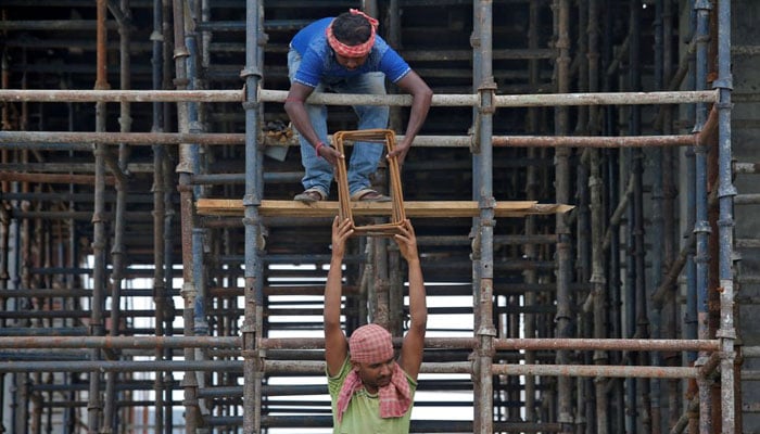 Labourers work at the construction site of a residential building on the outskirts of Kolkata, India, July 5, 2019. REUTERS/Rupak De Chowdhuri/Files