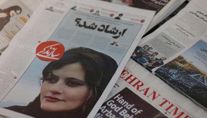 ایرانی اخلاقی پولیس کے ہاتھوں گرفتار ہونے کے بعد مرنے والی خاتون مہسا امینی کی کور تصویر والا ایک اخبار تہران، ایران میں 18 ستمبر 2022 کو دیکھا جا رہا ہے۔ - رائٹرز