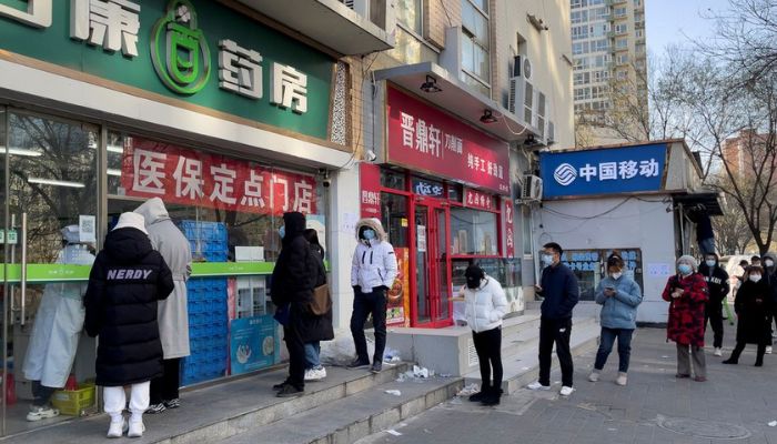 People wearing masks line up outside a pharmacy to buy products as coronavirus disease (COVID-19) outbreaks continue in Beijing, China December 6, 2022.— Reuters
