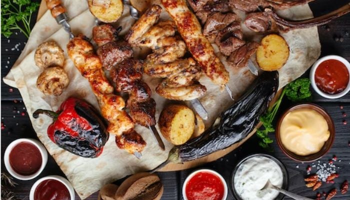 Grilled kebab with grilled peppers and different sauces.— Unsplash