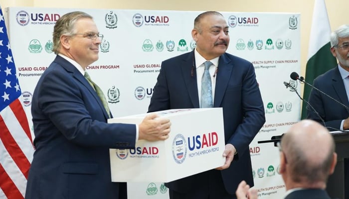 Federal Health Minister Abdul Qadir Patel (right) receives medical supplies from US Ambassador to Pakistan Donald Blome during a ceremony at the Ministry of National Health Services in Islamabad on December 7, 2022. — Twitter/@nhsrcofficial