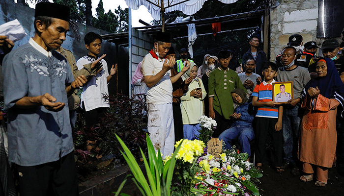 Family and relatives of Agus Sofyan, a police officer who was killed in a blast at a district police station, that according to authorities was a suspected suicide bombing, pray during the funeral in Bandung, West Java province, Indonesia, December 7, 2022. — Reuters