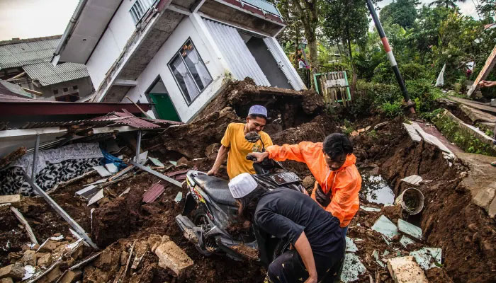 Villagers salvage items from damaged houses on Nov. 22, 2022 following a 5.6-magnitude earthquake that killed at least 162 people in Cianjur, Indonesia - AFP