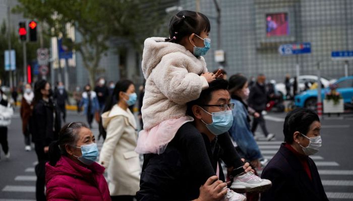 People wearing face masks cross a street, as coronavirus disease (COVID-19) outbreaks continue in Shanghai, China, December 8, 2022.— Reuters