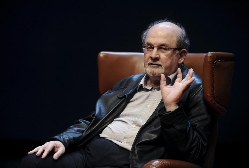 مصنف سلمان رشدی 7 اکتوبر 2015 کو شمالی اسپین کے ایویلس کے نیمیئر سینٹر میں اپنی تازہ ترین کتاب ٹو ایئرز ایٹ ماہ اور اٹھائیس راتیں پیش کرنے سے پہلے ایک نیوز کانفرنس کے دوران اشارہ کر رہے ہیں۔— رائٹرز