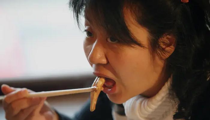 A representational image of an Asian woman eating food. — Reuters