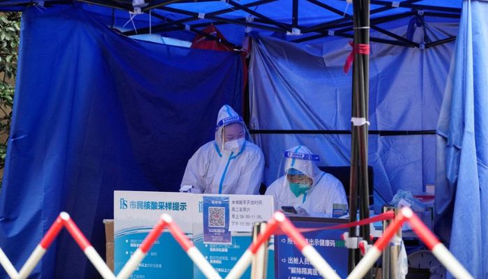 Workers in protective suits wait for people at a nucleic acid testing site, as the coronavirus disease (COVID-19) outbreak continues, in Shanghai, China, December 9, 2022.— Reuters