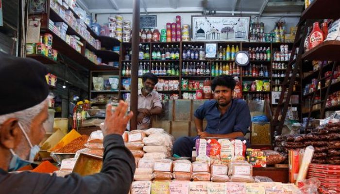 A shopkeeper listens to a customer as he sells groceries at a shop in a market in Karachi, Pakistan June 10, 2022.— Reuters