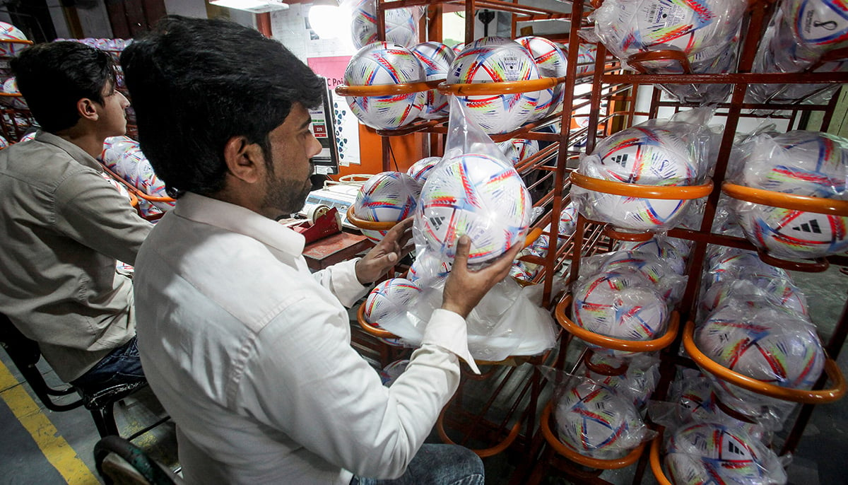 Workers check the finish of soccer balls before packing them in the soccer ball factory in Sialkot, Pakistan November 30, 2022. — Reuters