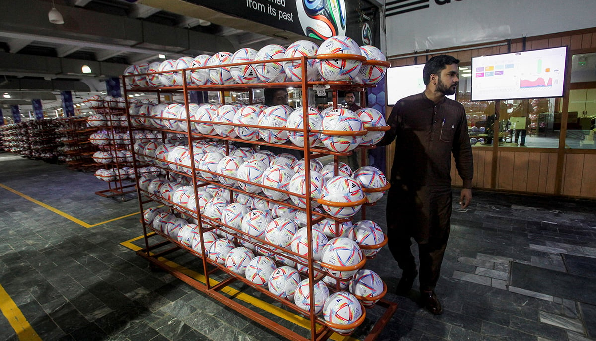 A worker moves a lot of finished balls out of the production area inside the soccer ball factory, in Sialkot, Pakistan November 30, 2022. — Reuters