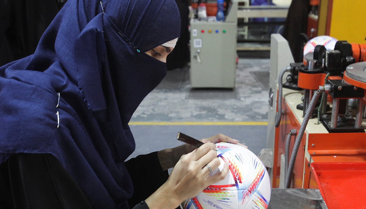 A worker conducts the final check to fix any cavity in the seams of a ball inside the soccer ball factory in Sialkot, Pakistan December 2, 2022. — Reuters