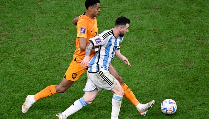 Argentinas forward Lionel Messi (R) fights for the ball with Netherlands forward Cody Gakpo during the Qatar 2022 World Cup quarter-final football match between The Netherlands and Argentina at Lusail Stadium, north of Doha on December 9, 2022. AFP