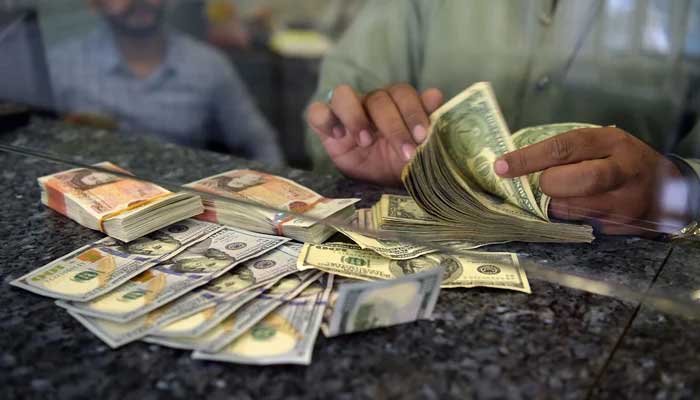 A currency dealer counts notes in this undated photo. — AFP