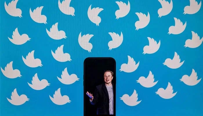 This illustration taken on August 05, 2022, shows a cellphone displaying a photo of Elon Musk placed on a computer monitor filled with Twitter logos in Washington, DC. — AFP