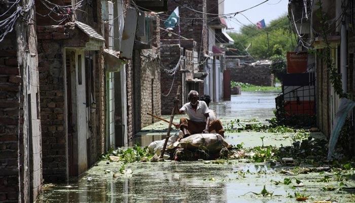 Men use a makeshift raft as they cross a flooded street in a residential area, following rains during the monsoon season in Hyderabad, Pakistan September 5, 2022. — Reuters