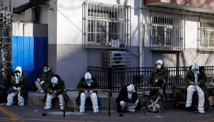 Pandemic control workers in protective suits sit in a neighbourhood that used to be under lockdown, as coronavirus disease (COVID-19) outbreaks continue, in Beijing, China December 10, 2022. — Reuters