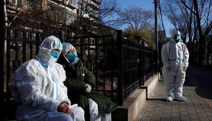 Pandemic control workers in protective suits sit in a neighbourhood that used to be under lockdown, as coronavirus disease (COVID-19) outbreaks continue, in Beijing, China December 10, 2022. — Reuters