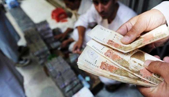 An image of a cashier counting Rs5,000 bank notes — SBP