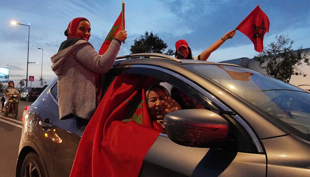 خواتین 10 دسمبر 2022 کو سیمی فائنل میں ترقی کا جشن مناتے ہوئے کار سے مراکش کے جھنڈے لہرا رہی ہیں۔ - رائٹرز